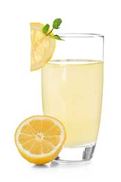 Pure Freshly Squeezed 100% Lemon Juice. Lemon Juice in a Glass Next to a Slice of Lemon.