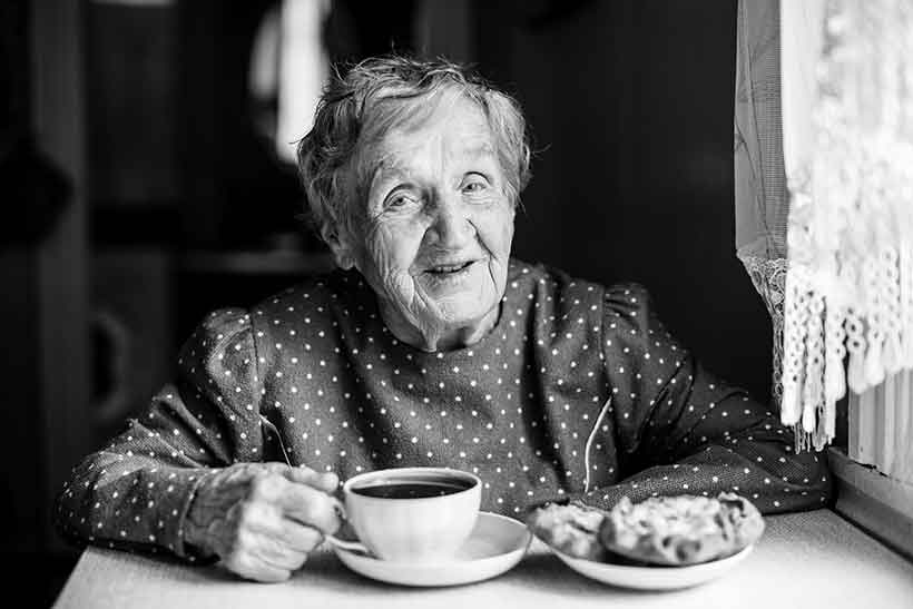 Longevity Studies Show Coffee May Help You Live Longer. Picture of an Elderly Lady Enjoying a Cup of Coffee.