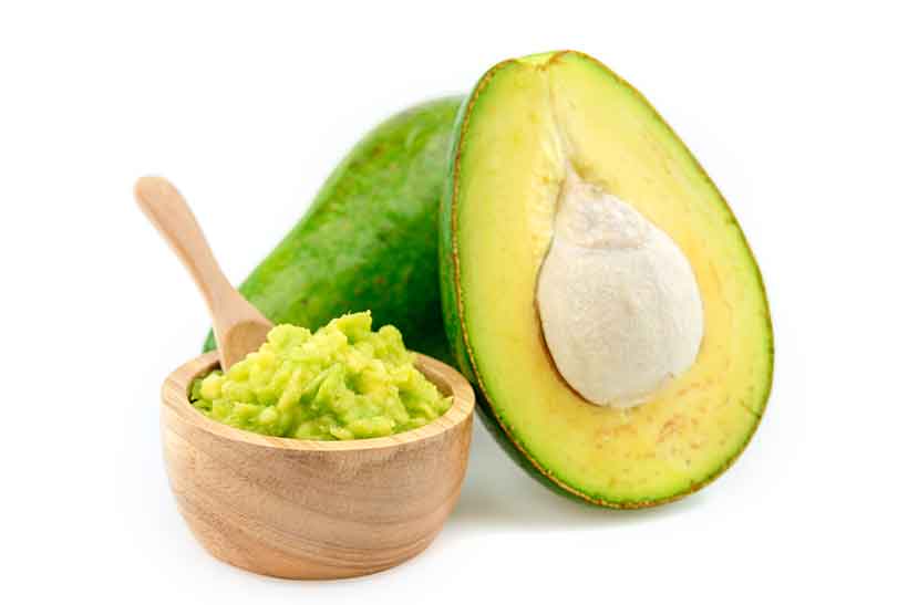 Avocado: Possibly the World's Healthiest Fruit. An Avocado Cut in Half Next To a Bowl of Guacamole.