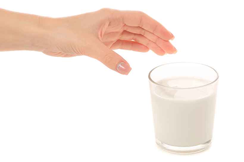 Milk: A Nutritious Dairy Drink. Someone Reaching For a Glass of Fresh Whole Milk.