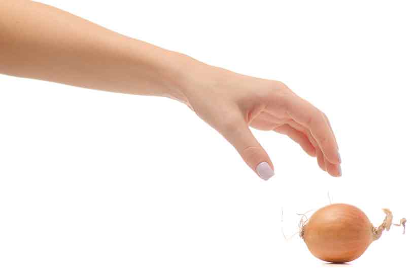 Onions: One of the Most Healthy Foods On Earth. A Hand Reaching For a Yellow Onion.