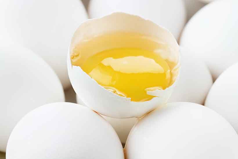 Some People Restrict Egg Yolks Due To Dietary Cholesterol Fears. CLose-Up Photo of Eggs and a Shell Containing Egg Yolk.