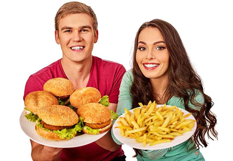 Slim and Eating An Unhealthy Diet? It's Not Healthy. A Young Couple Eating a Plate of Hamburgers and French Fries.