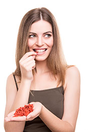 Picture of a Young Woman Eating a Healthy Snack Called Goji Berries.