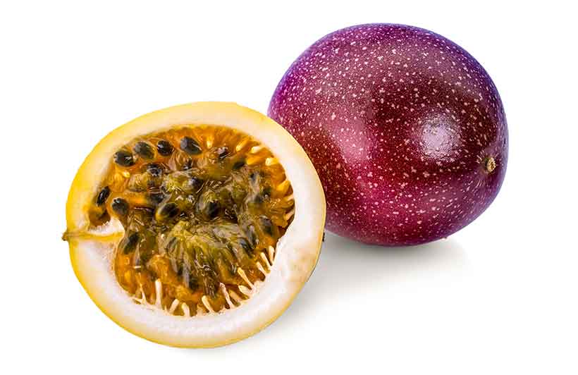 Whole Passion Fruit and Half Passion Fruit Showing Orange Flesh.